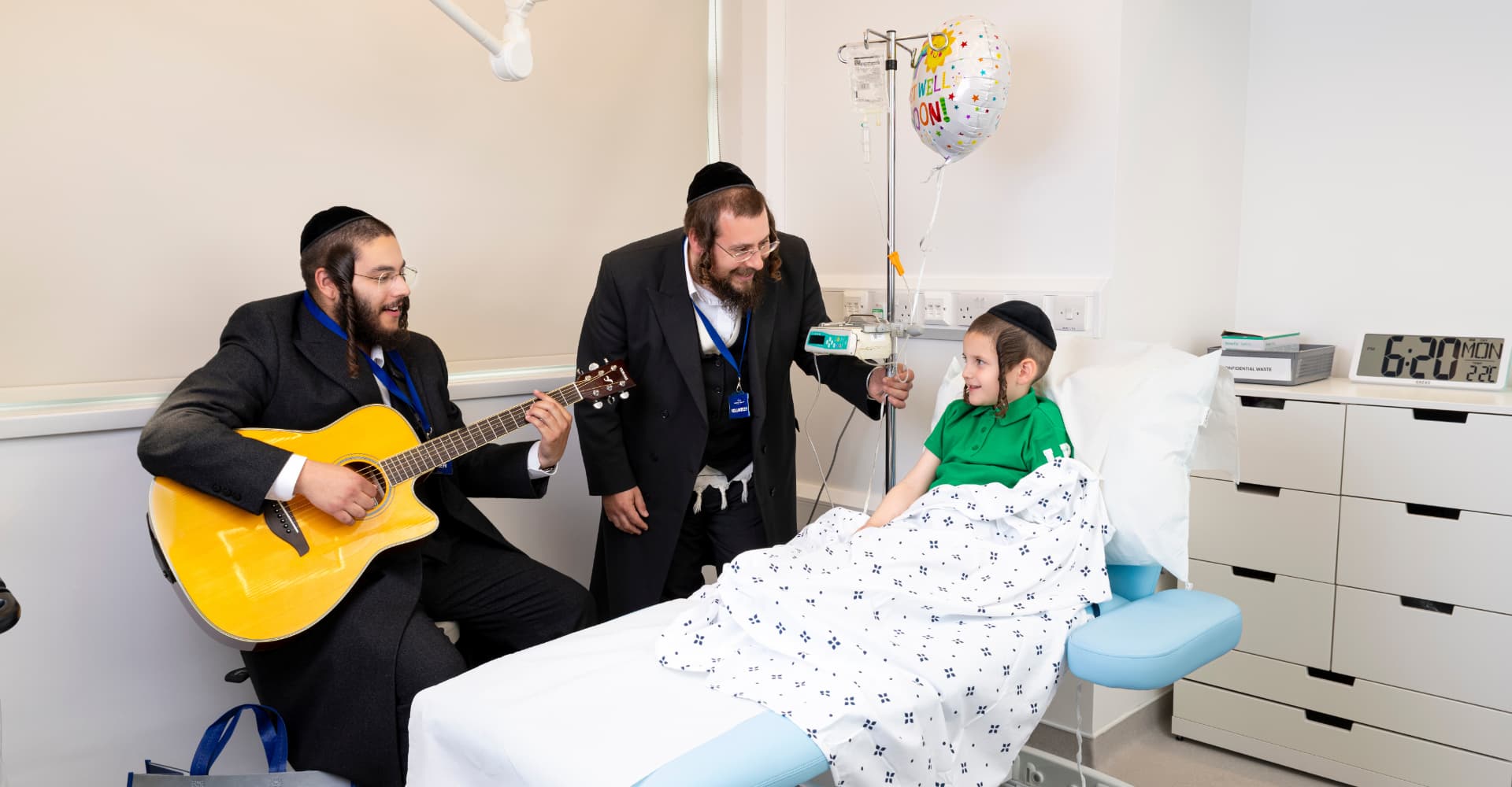 Bikur Cholim volunteers playing music for a child in hospital